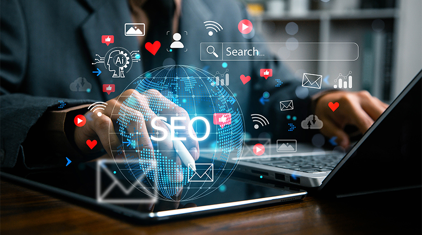 Person Using Laptop And Tablet With Digital SEO Icons Floating Around A Globe Person Using Laptop And Tablet With Digital SEO Icons Floating Around A Globe