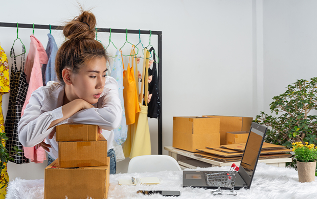 a woman seated at a desk cluttered with several boxes a woman seated at a desk cluttered with several